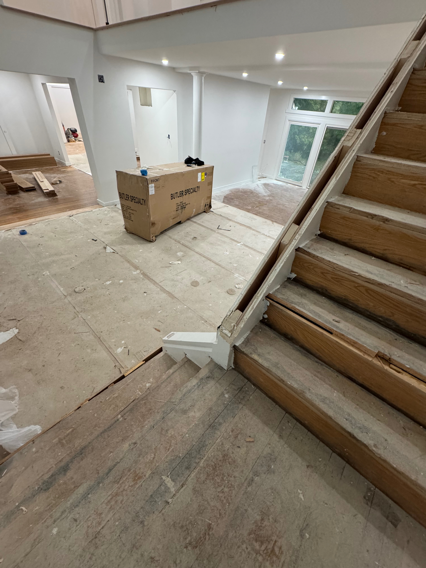 Staircase before renovation with dated wood finish
