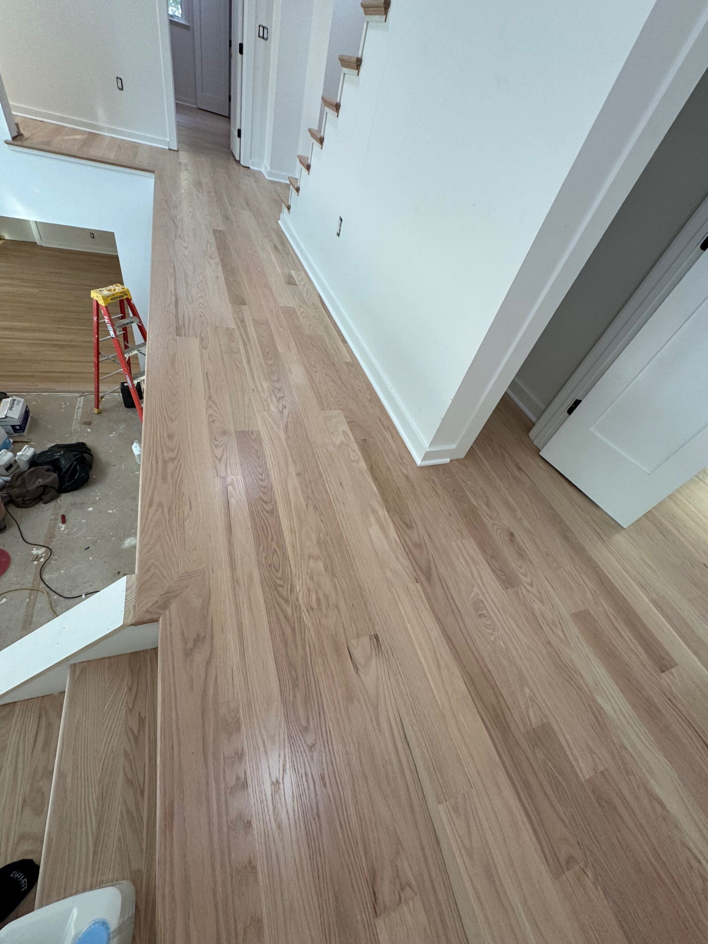 Upper landing finished with wide plank light hardwood flooring