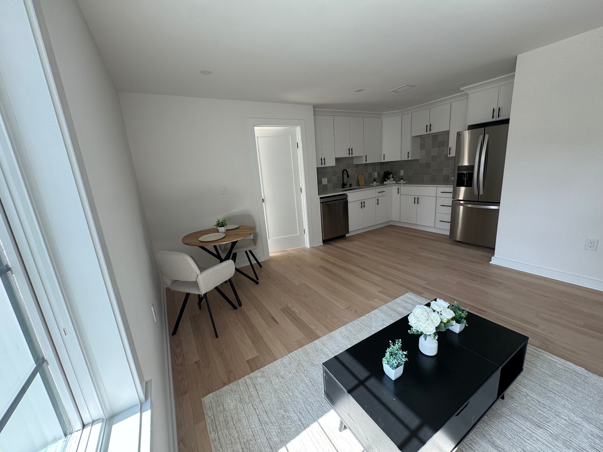 Open kitchen and living area with light hardwood floors
